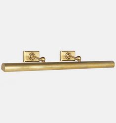 two brass handles on a white wall