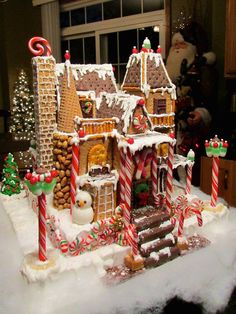 a gingerbread house is decorated with candy canes and candies