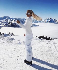 a woman standing on top of a snow covered slope