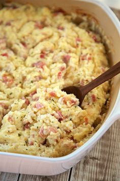 chicken cordon bleu rice bake in a casserole dish with a wooden spoon