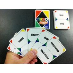 a hand is holding four cards with words on them and the other two are in front of it