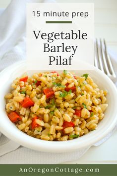 a white bowl filled with vegetable barley pilaf next to a fork and napkin