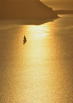 a sailboat in the water at sunset