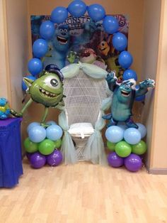 some balloons that are in the shape of monsters on a chair and other decorations for a birthday party