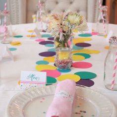 a table set for a birthday party with confetti, candles and napkins