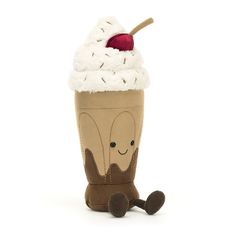 a stuffed cupcake with a cherry on top and whipped cream in the middle, sitting next to a toy scooper