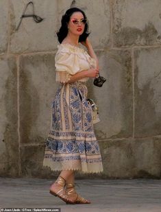 a woman in a dress is walking down the street