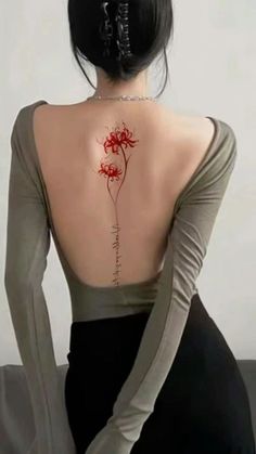 the back of a woman's body with a flower tattoo on her left shoulder