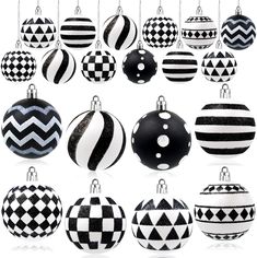 black and white christmas ornaments hanging from chains on a white background with reflection in the middle