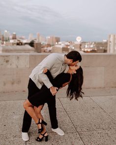 a man and woman kissing on the roof of a building