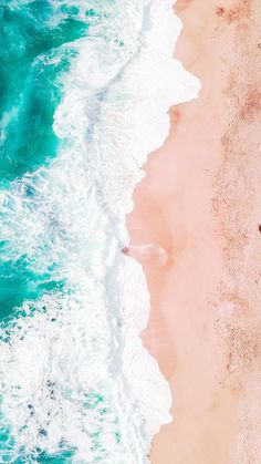 an aerial view of the ocean and beach with waves crashing on it's shore