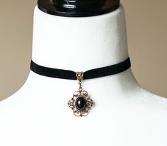 Elevate your style with our Black Velvet Choker with Black Agate Pendant. This stunning piece combines the elegance of black velvet with the natural beauty of a black agate stone, creating a versatile accessory perfect for any occasion. Product Features: Material: Luxurious black velvet ribbon and polished black agate stone Pendant Size: Approximately 1.5 inches in height Choker Length: Adjustable from 12 to 14 inches to fit comfortably Closure: Secure lobster clasp with extender chain Style: Go Gothic Boho, Black Velvet Ribbon, Velvet Choker Necklaces, Crystals Necklace, Floral Filigree, Black Velvet Choker, Raw Crystals, Vintage Choker, Filigree Jewelry