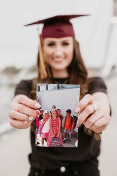 a woman in a graduation cap holding up a photo