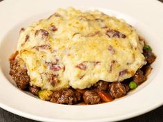 a white plate topped with mashed potatoes and meat