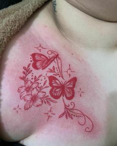 a woman's chest with butterflies and flowers on her chest, in red ink