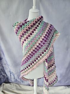 a crocheted shawl draped over a mannequin