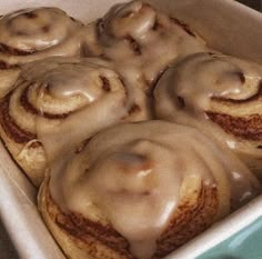 a pan filled with cinnamon rolls covered in icing