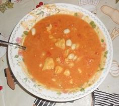 a bowl of soup is sitting on a table with utensils and napkins