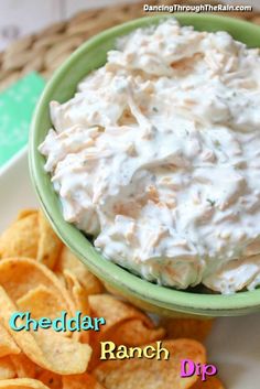 a green bowl filled with dip next to chips