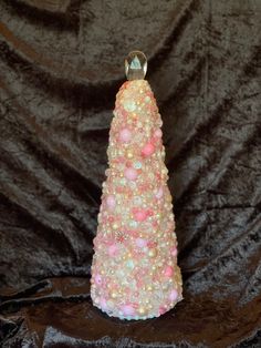 a pink and white christmas tree made out of beads