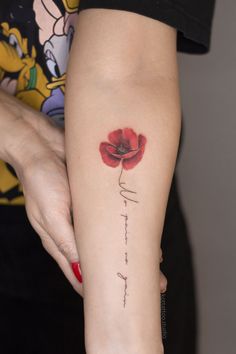 a woman with a red flower on her arm and the word faith written in cursive writing