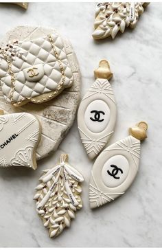 chanel cookies are arranged on a marble table with gold trimmings and decorations