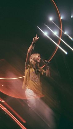 a man standing on top of a stage holding a microphone in front of his face