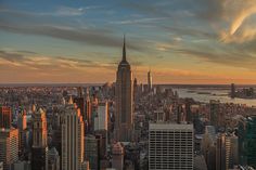 an aerial view of new york city with the empire building in the foreground at sunset