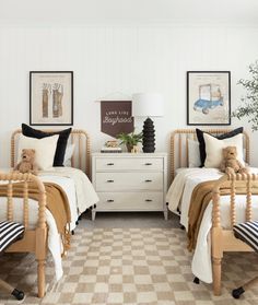 two twin beds in a bedroom with black and white decor on the walls, checkered floor