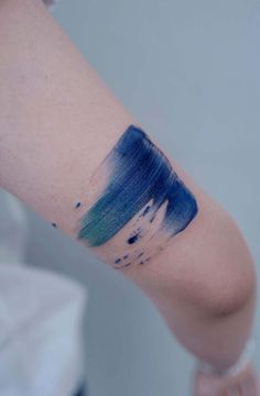 a person's arm with blue and green ink on the left side of their arm