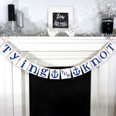 a banner that says tying the knot on it in front of a fireplace mantel