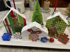 three small christmas houses on a white tray