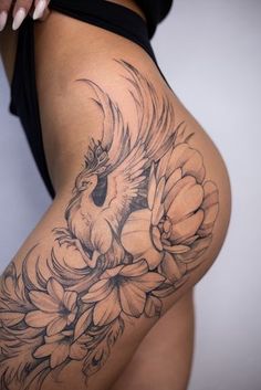 a woman's thigh with flowers and a bird on it