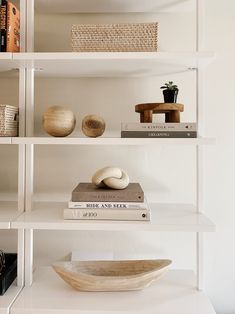 a white shelf filled with books and bowls