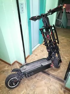 an electric scooter parked in front of a mirror on the floor next to a door