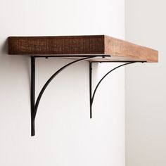 a wooden shelf with metal brackets on it