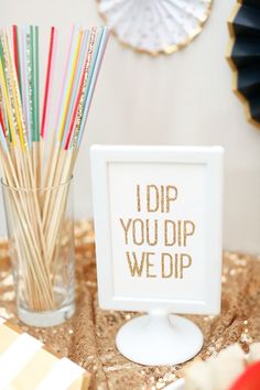 there is a sign that says i dip you dip we dip next to a glass with straws in it