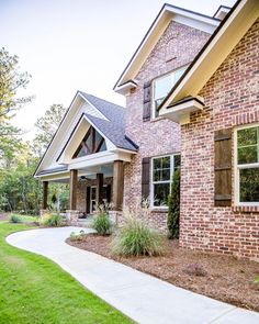 a brick house with green grass and trees