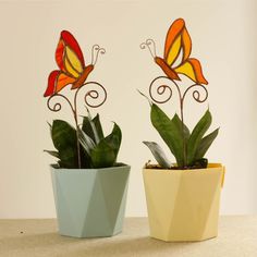 two potted plants with colorful butterflies on them