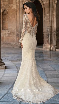 the back of a wedding dress with long sleeves and open shoulders, in front of an archway