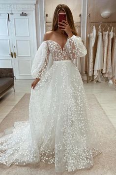 a woman is taking a selfie in her wedding dress while wearing a white gown