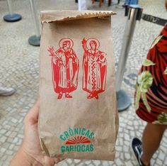 a person holding up a brown paper bag with an image of the virgin mary and jesus on it