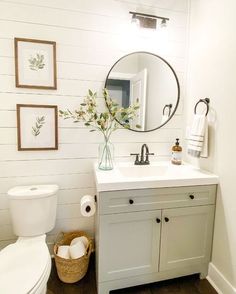 a bathroom with white walls and wood floors