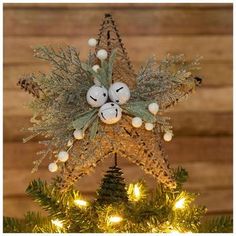 an ornament hanging from the top of a christmas tree with lights on it