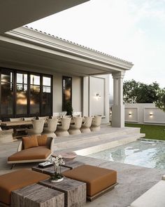 an outdoor living area with couches and tables next to a swimming pool in the background