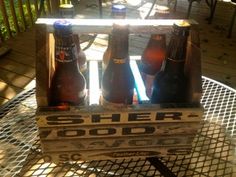 six beer bottles in a crate on a table