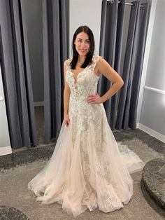 a woman standing in front of a mirror wearing a wedding dress