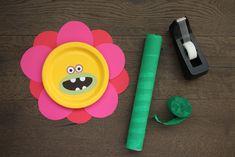 a paper plate with a monster face on it next to a green piece of tape