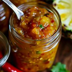 a jar filled with food sitting on top of a wooden table next to other jars