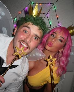 a man and woman dressed up in costume posing for the camera with props on their heads